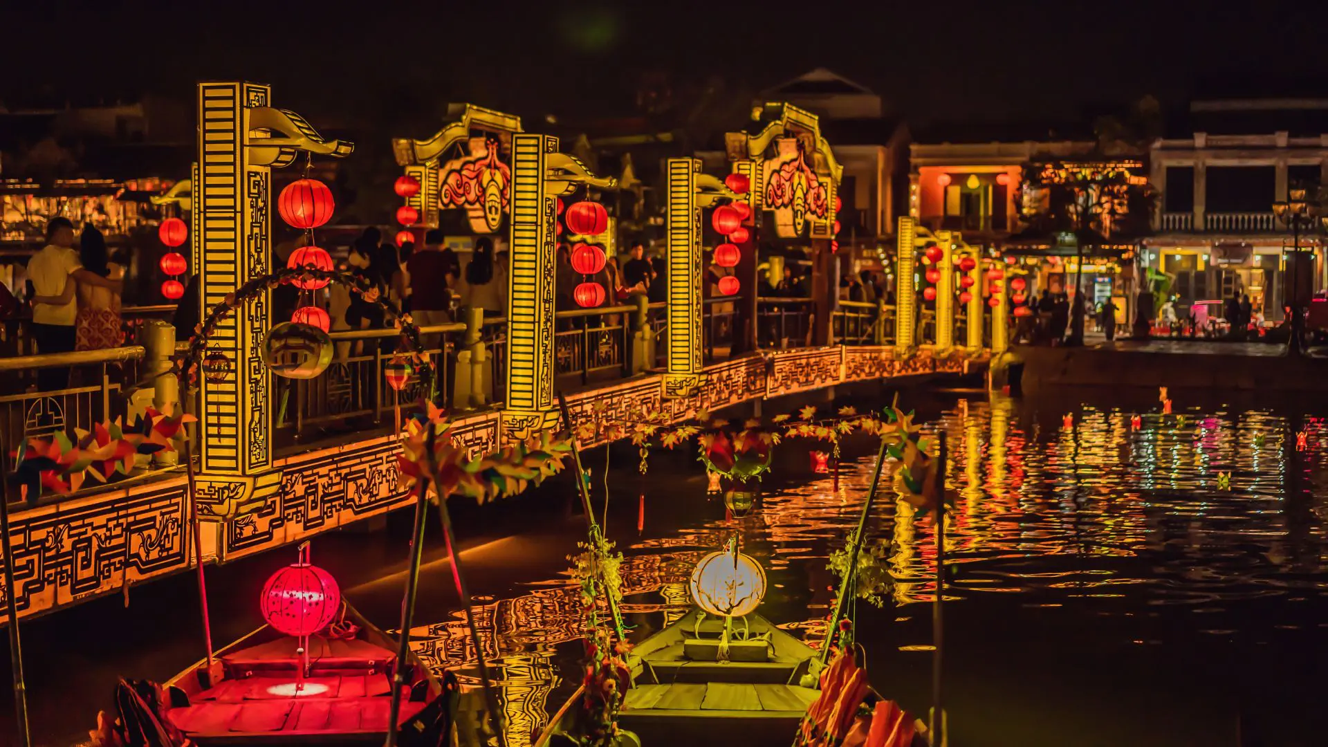 MERCADO DE HOI AN NO VIETNAME 3 Ponte pedonal de Hoi An iluminada à noite com lanternas vermelhas, refletida na água do rio