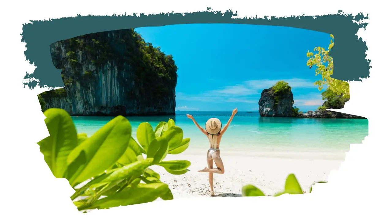 Woman in a straw hat does the tree pose on a white-sand beach between sea stacks