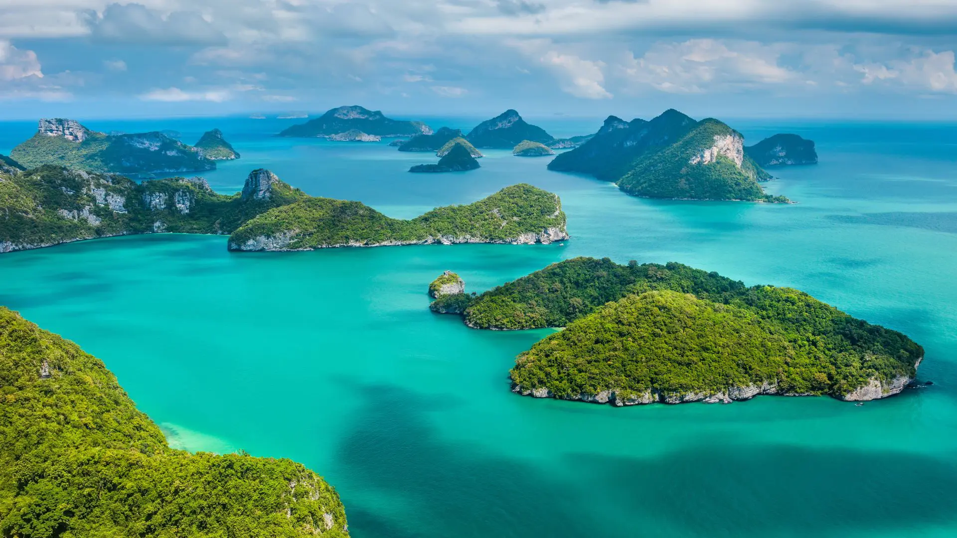 Angthong Marine Park from Koh Samui Aerial view of dozens of jungle-covered limestone islands in a turquoise sea, with high clouds in the background