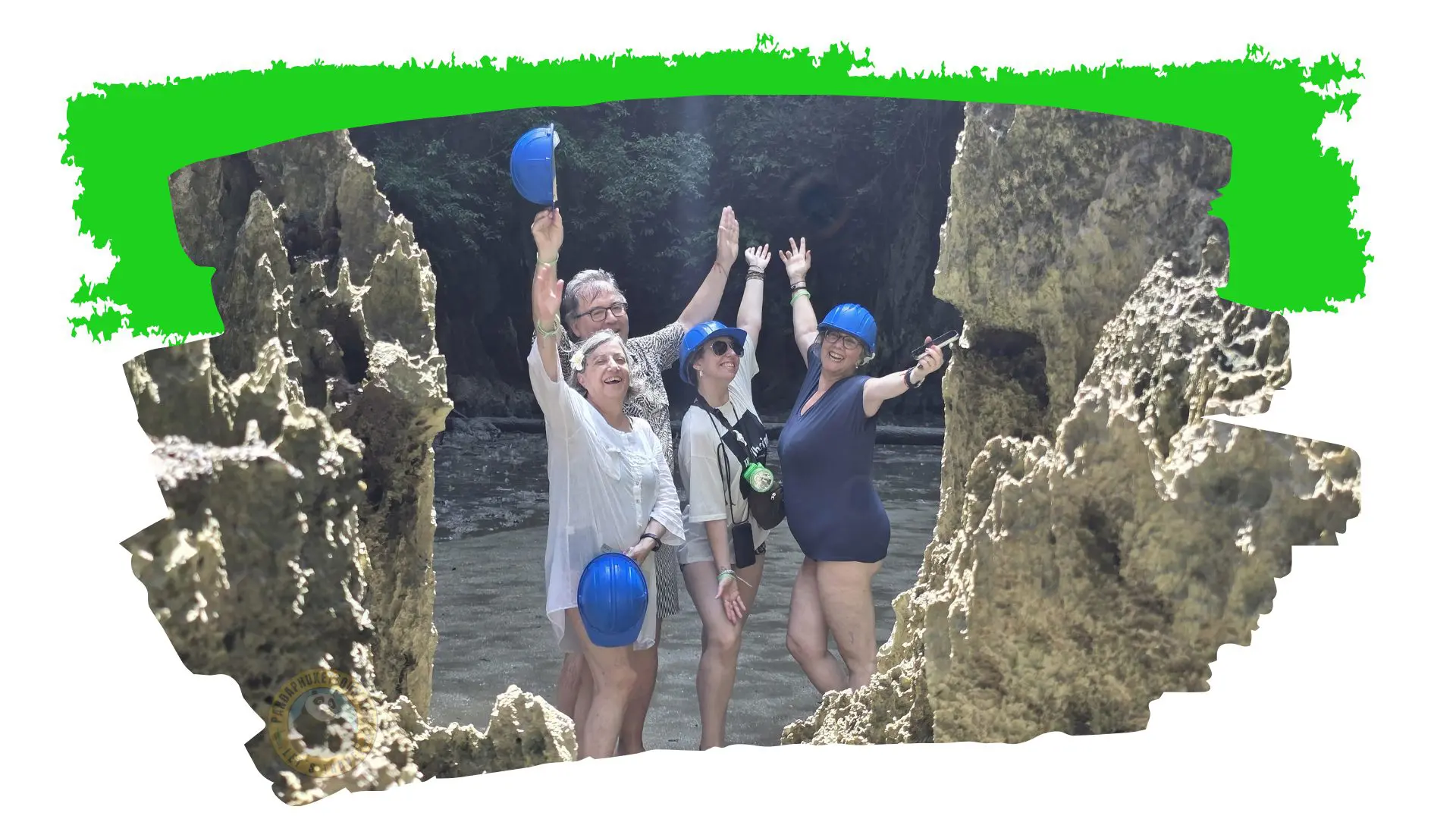 Quatro viajantes erguem os braços entre rochas calcárias; um agita um capacete azul por cima da cabeça