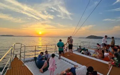 Voyageurs contemplant le coucher de soleil depuis la proue du catamaran