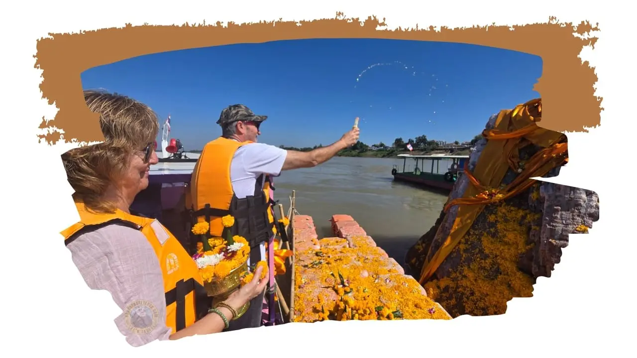 Dois viajantes de colete num barco: ele atira água ao ar e ela segura flores, junto a uma rocha com panos dourados