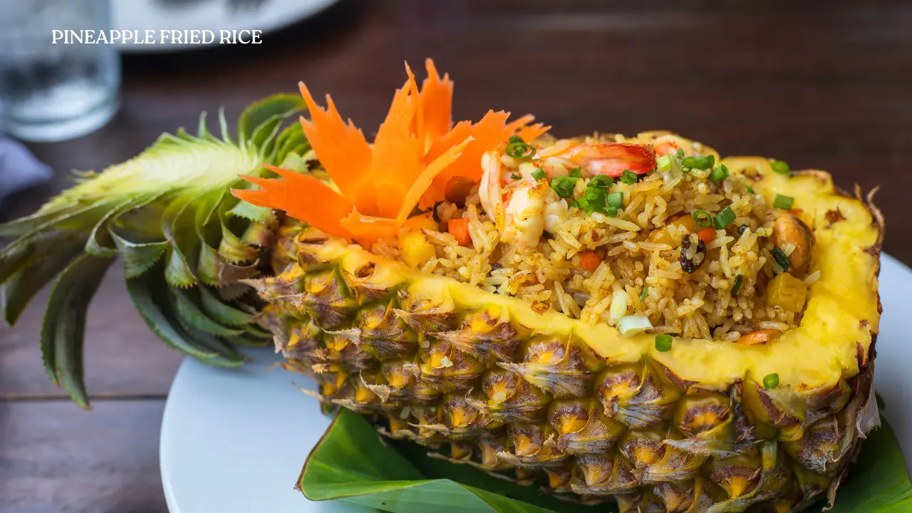 Shrimp fried rice served in half a pineapple, garnished with a carved carrot flower